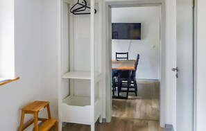 A hallway with a wooden stool, a white door, and a dining area with a table and chairs. - Pet friendly apartment in Barth with WiFi (Barth)