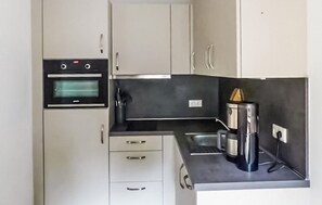 A compact kitchen with a built-in oven, a coffee maker, and a sink. - Pet friendly apartment in Barth with WiFi (Barth)
