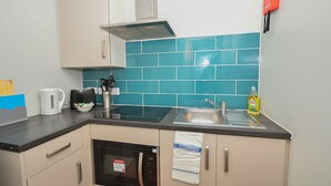A kitchen with a microwave, kettle, and sink. - Spacious Budget 3-Bed Sheffield Centre Apt (Sheffield)