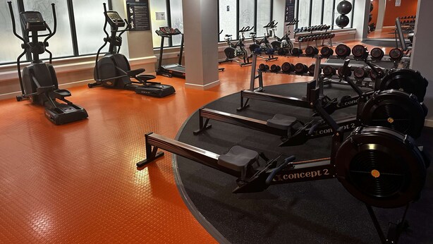 A gym with cardio machines, weight benches, and dumbbells. - Spacious Budget 3-Bed Sheffield Centre Apt (Sheffield)