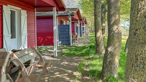 Una fila di cabine di legno rosse con un vialetto in mattoni che le conduce.
