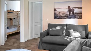 Ett rum med en våningssäng, en soffa och en målning av en häst.