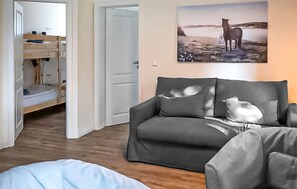 Ein Zimmer mit einem Etagenbett, einer Schlafcouch und einem Gemälde von einem Pferd.