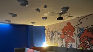 A room with a blue wall, a mural of trees, a sofa, and a small table.