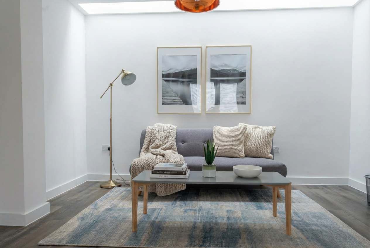 A modern living room with a sofa, coffee table, and floor lamp.