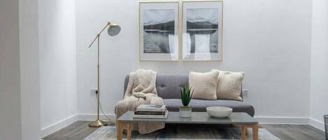 A modern living room with a sofa, coffee table, and floor lamp.