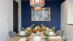 A dining table set with plates, glasses, and cutlery, a vase, and a bowl. - Modern & Spacious 2BED Apartment by Old Trafford (Manchester)