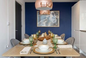 A dining table set with plates, glasses, and cutlery, a vase, and a bowl. - Modern & Spacious 2BED Apartment by Old Trafford (Manchester)