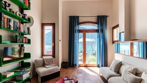 Ein Wohnzimmer mit Sofa, Couchtisch, Bücherregal und Fernseher.