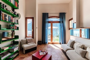 Ein Wohnzimmer mit Sofa, Couchtisch, Bücherregal und Fernseher.