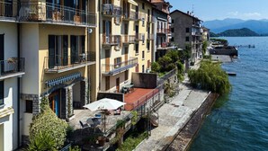Ein Hotel am Wasserufer mit Balkonen, einem Steinweg und Seeblick.
