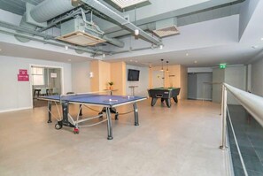 A spacious indoor area with a ping pong table, a pool table, and a staircase. - Modern Central Coventry Studio – Gym Access (Coventry)