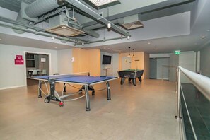A spacious indoor area with a ping pong table, a pool table, and a staircase. - Bright & Cosy Studio in Central Coventry (Coventry)
