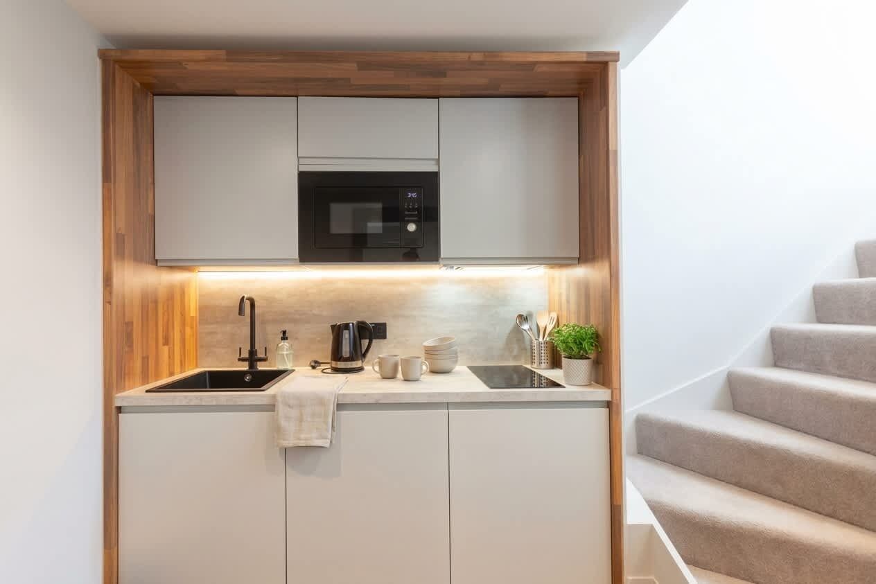 A compact kitchen with a built-in microwave, a sink, and a small countertop area.