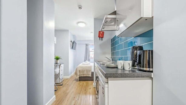 A modern kitchen with a built-in oven, a coffee machine, and a microwave. - Cosy Budget Double Studio in Nottingham Centre (Nottingham)