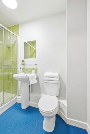 A bathroom with a white sink, toilet, and shower area. - Cosy Budget Double Studio in Nottingham Centre (Nottingham)