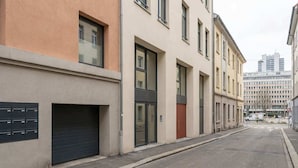 A street view with buildings, a garage door, and a clear sky. - Cosy Budget Double Studio in Nottingham Centre (Nottingham)