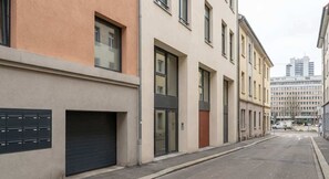 A street view with buildings, a garage door, and a clear sky. - Cosy Budget Double Studio in Nottingham Centre (Nottingham)