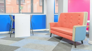 A room with a checkered carpet, a red armchair, a white desk, and a window with a view of a brick building. - Modern Budget Single Studio in Central Nottingham (Nottingham)