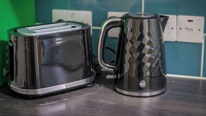 Una cocina con un tostador y una tetera sobre una encimera.