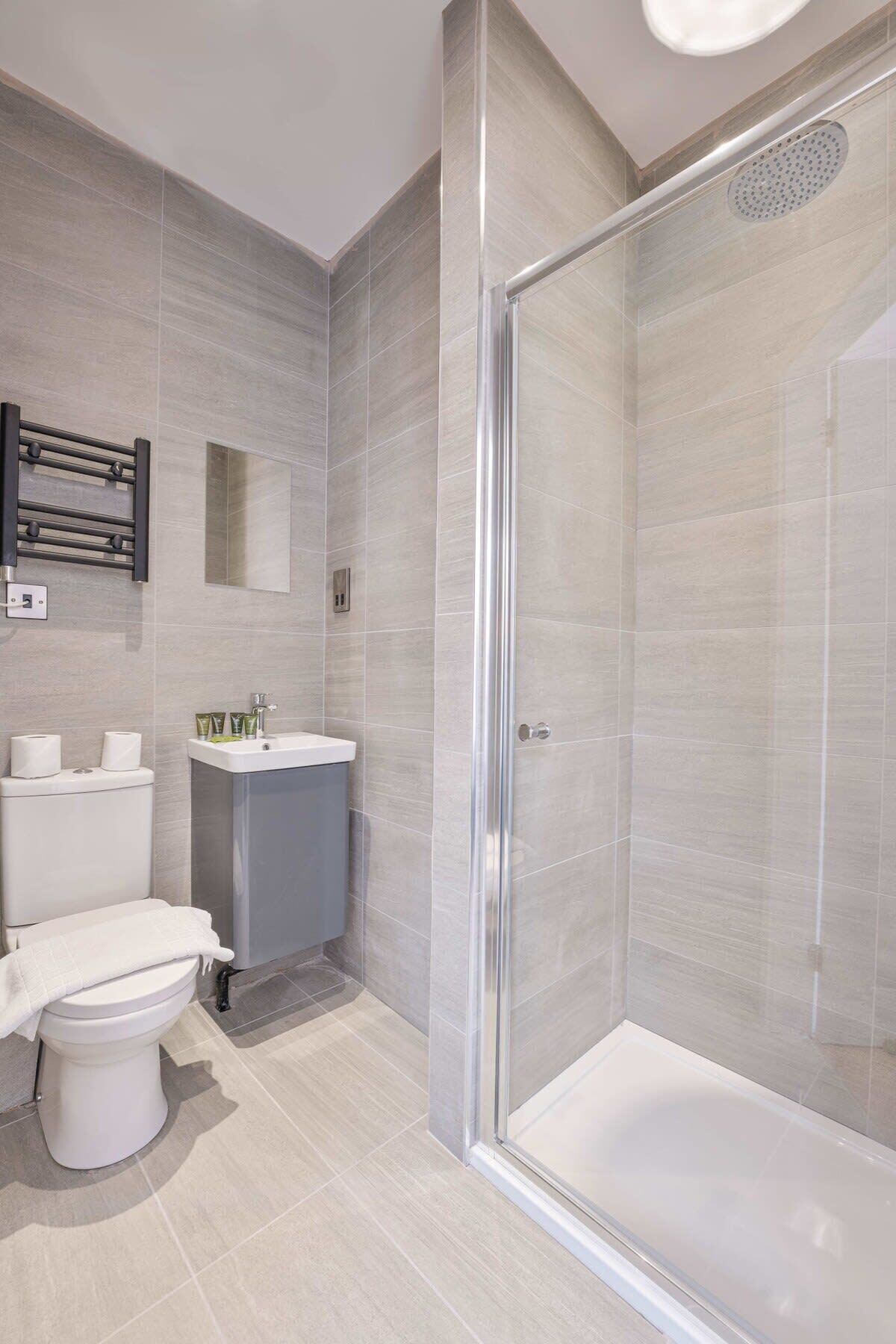 Un baño moderno con inodoro, lavamanos y ducha.
