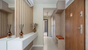 A modern hotel corridor with a reception desk, wooden panel walls, and a bench. - Family Apartment with Balcony | Air Conditioning, Parking | Tarczyński Arena (Wrocław)
