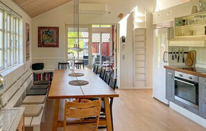 A kitchen with a wooden table, chairs, and a built-in oven. - Stunning home in Vig with WiFi (Vig)
