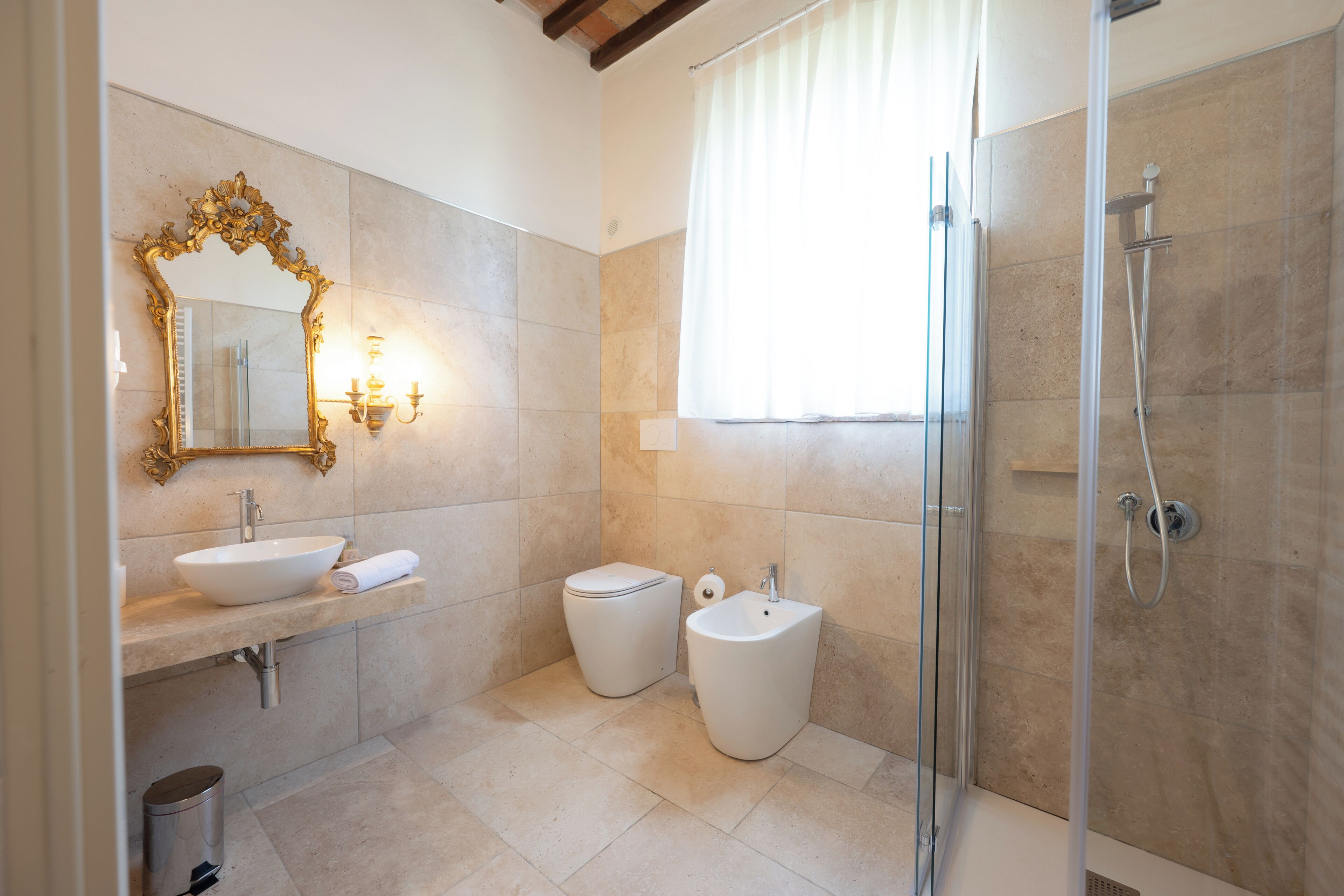 Un baño con lavamanos, inodoro, bidé y ducha.