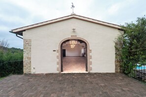 A building with a tiled entrance, a stone wall on one side, and a metal fence on the other. - Villa Tegolato (Barberino Tavarnelle)