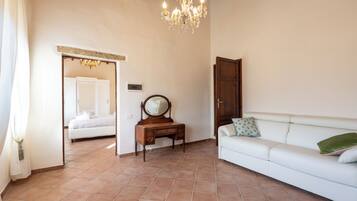 Una habitación con cama, cómoda, espejo, sofá y candelabro.