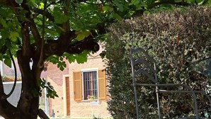 A gravel courtyard with a metal structure, a tree, and a building with windows and shutters. - Cascina Lungamerenda - Relax in Monferrato (Costigliole d'Asti)