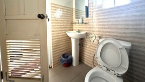 Un bagno con il water, un lavandino e uno specchio.