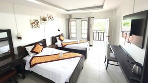 Una camera d'albergo con due letti, una scrivania, una TV e un balcone con vista.