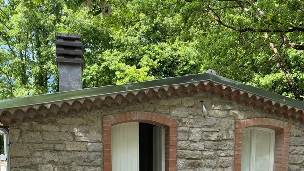 A stone building with a tiled roof, a door, and a window. - Dependance Dafne is a refined retreat nestled in the quietness of nature (Vinchiaturo)