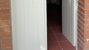 A hallway with a white door and a brick wall. - Dependance Dafne is a refined retreat nestled in the quietness of nature (Vinchiaturo)