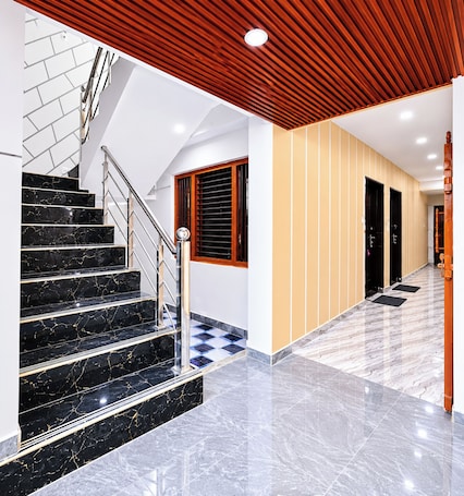 Un intérieur moderne avec un escalier en marbre, un plafond en bois et un motif de carreaux au sol.. Hotel SURYA-ANSH KHAJURAHO