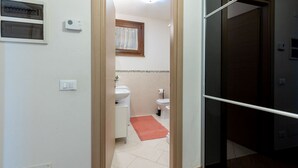 Un baño con lavabo, inodoro y ventana.