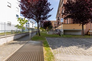 A paved pathway, a bicycle, a building with a parking sign, and a tree with red leaves. - A comfortable and practical 40 square meters studio apartment, perfect for three people, located on the first floor of a building with an elevator (NOT accessible to disabled guests).The property is located near Pisa Centrale Train Station, making it the (Pisa)