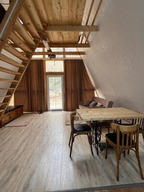 Une pièce de style loft avec un escalier en bois, une table à manger avec des chaises et un canapé.