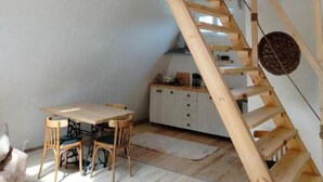 A loft-style room with a wooden staircase, a dining table, and a kitchen area. - Metsadzor Resort, Areni (Areni)