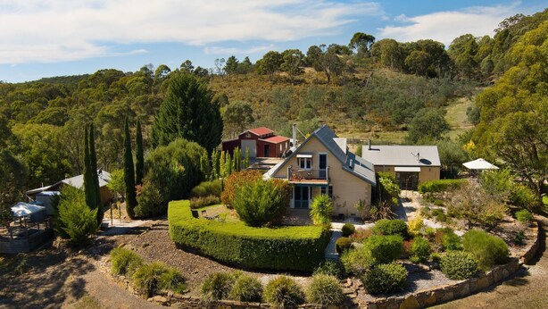 Ein Haus mit großem Garten, Pool und Blick auf die umliegenden Hügel.