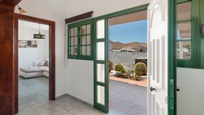 Una habitación con puerta verde, pared blanca y vista a un paisaje desértico.