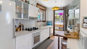 Een moderne keuken met witte kasten, een ingebouwde oven, een spoelbak en een houten aanrecht.