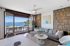 A modern living room with a sofa, a dining table, and a ceiling fan. - Villa 'Aster' with Sea View, Wi-Fi and Air Conditioning (Coti-Chiavari)