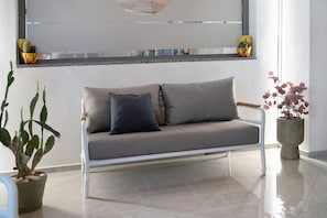 Ein modernes Wohnzimmer mit einer Couch, einem Blumentopf und einem Fenster mit Blick.