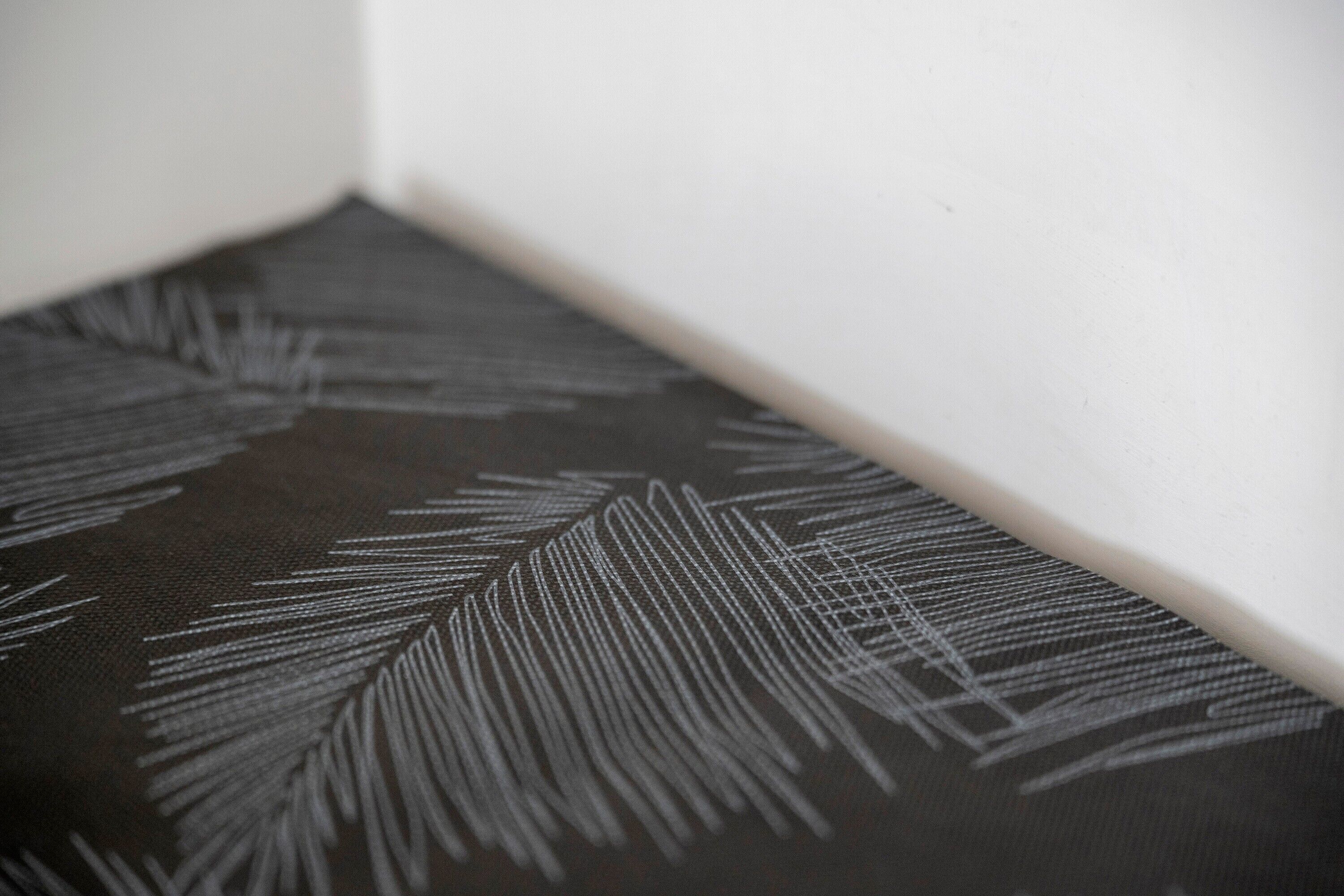 Un gros plan d’un tissu texturé orné d’un motif de feuilles.