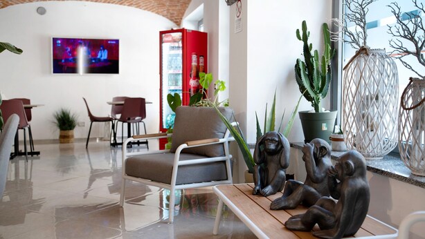 Een modern interieur met een zithoek, een aan de muur bevestigde televisie en diverse planten.