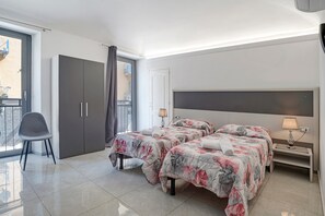 A hotel room with two beds, a chair, a desk, and a door leading to a balcony. - Room 'Stanza 101' with Balcony and Air Conditioning (Novara)