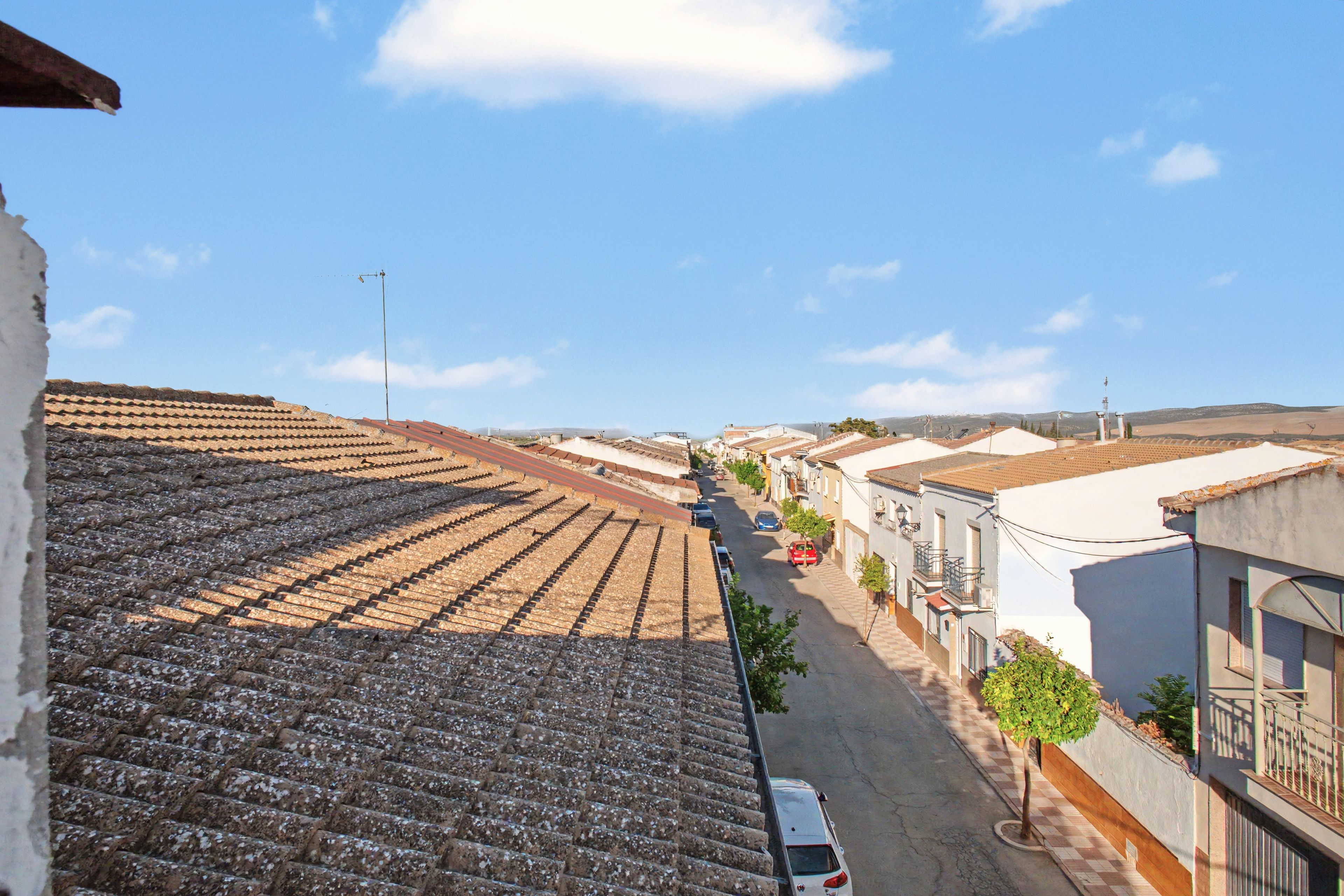Vista de carrer amb teules de terracota, un carrer estret i edificis amb balcons.