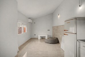 A modern kitchen with a built-in refrigerator, a white countertop, and a small white table.